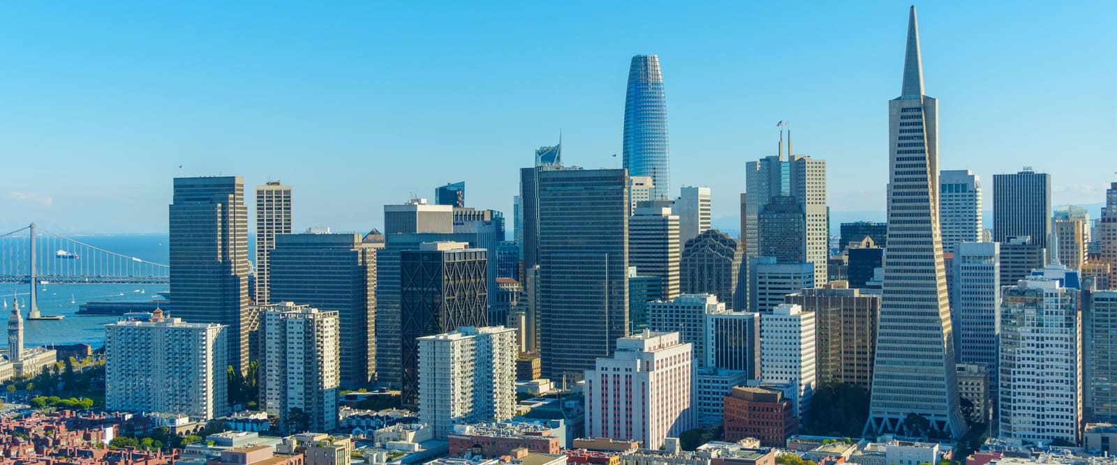 The San Francisco downtown skyline with the Bay Bridge in the distance
